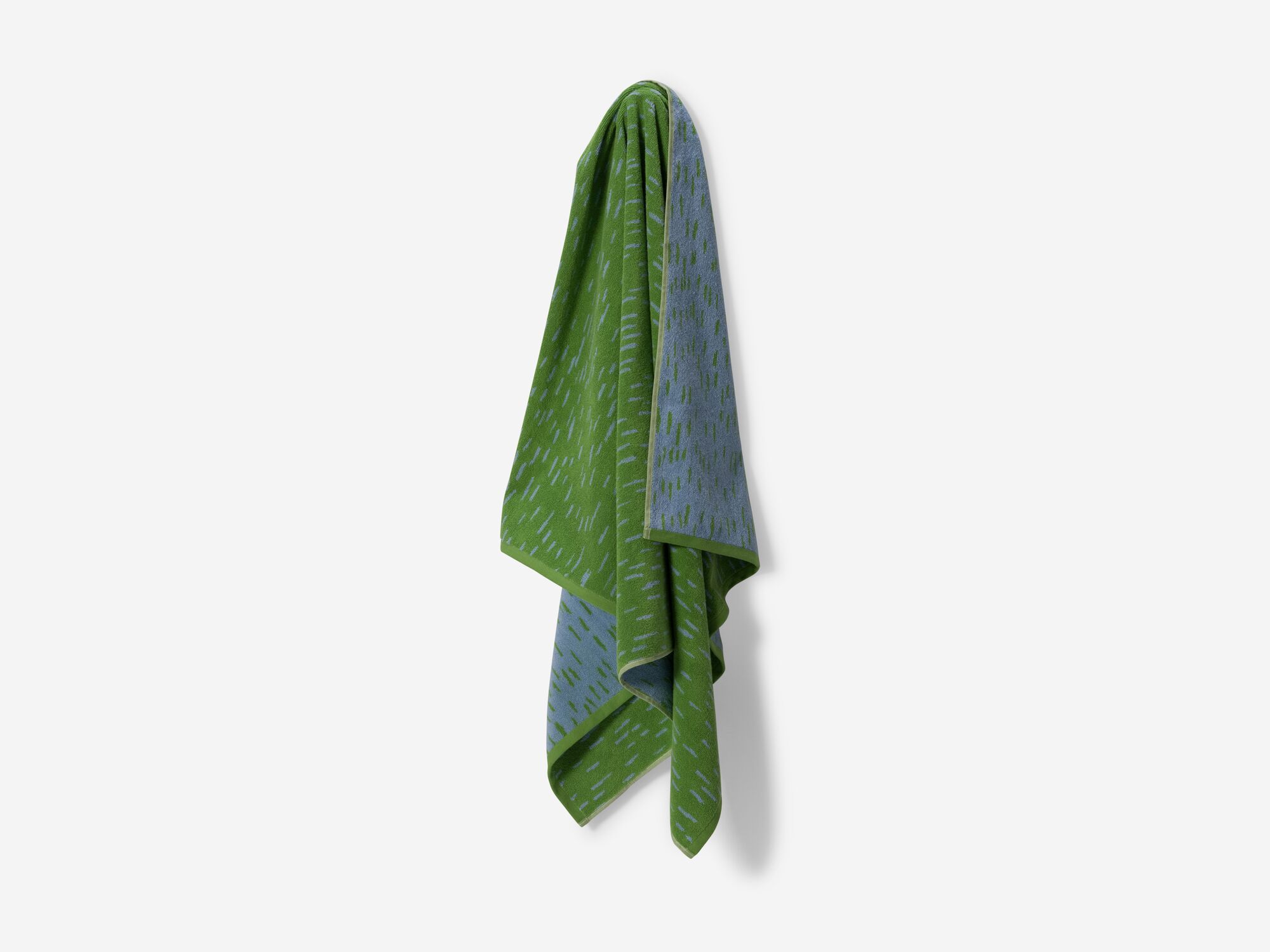 Green spotted bath towel hanging on peg